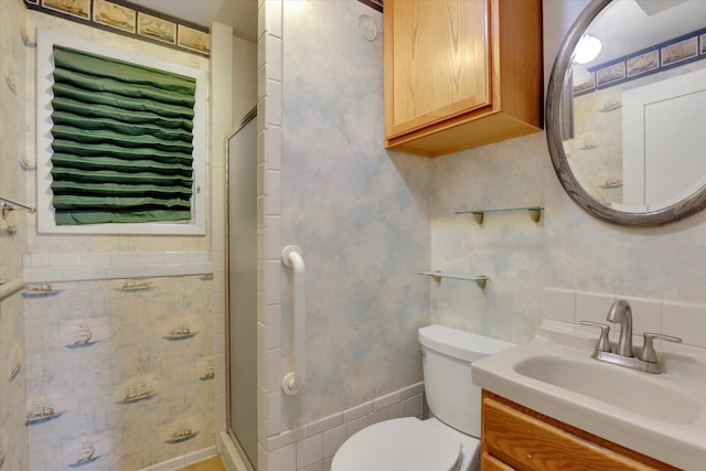 full bath with vanity, a shower stall, and toilet