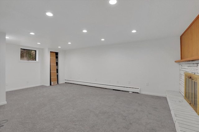 unfurnished living room featuring recessed lighting, baseboard heating, a glass covered fireplace, and carpet