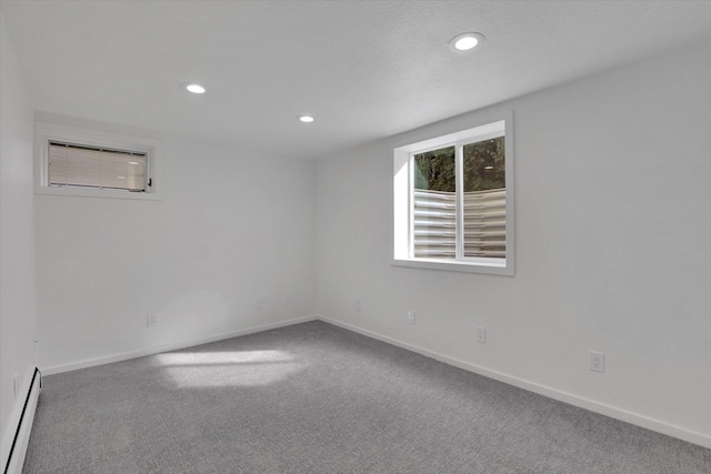 empty room with recessed lighting, a baseboard heating unit, baseboards, and carpet