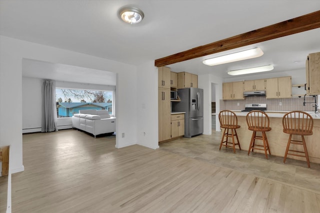 kitchen with under cabinet range hood, backsplash, stainless steel appliances, a peninsula, and light countertops