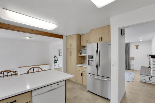 kitchen featuring beamed ceiling, light brown cabinetry, light stone counters, white dishwasher, and stainless steel fridge with ice dispenser