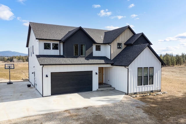 modern farmhouse featuring an attached garage, board and batten siding, driveway, and roof with shingles