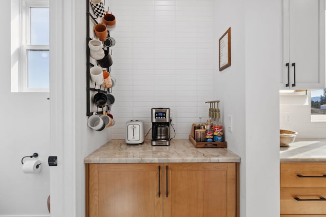 bar with tasteful backsplash and plenty of natural light