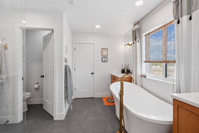 full bath featuring visible vents, a freestanding bath, vanity, and toilet