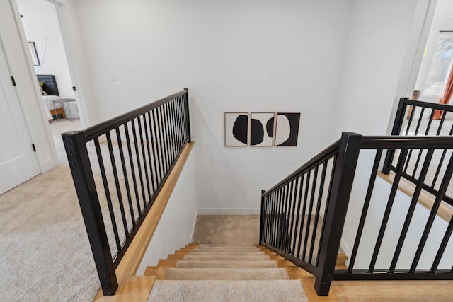 stairway featuring carpet flooring and baseboards