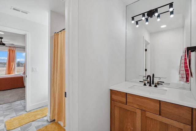 ensuite bathroom with visible vents, ceiling fan, ensuite bathroom, tile patterned floors, and vanity