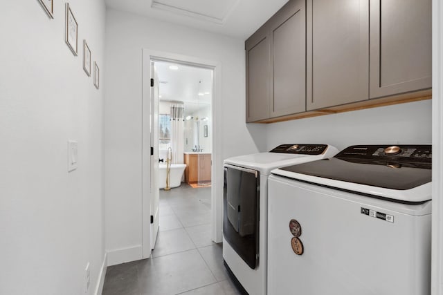 clothes washing area featuring light tile patterned flooring, cabinet space, and independent washer and dryer