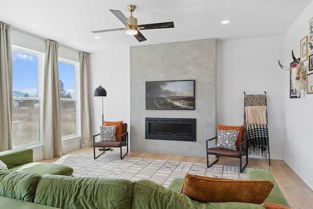 interior space with recessed lighting, wood finished floors, a fireplace, and ceiling fan