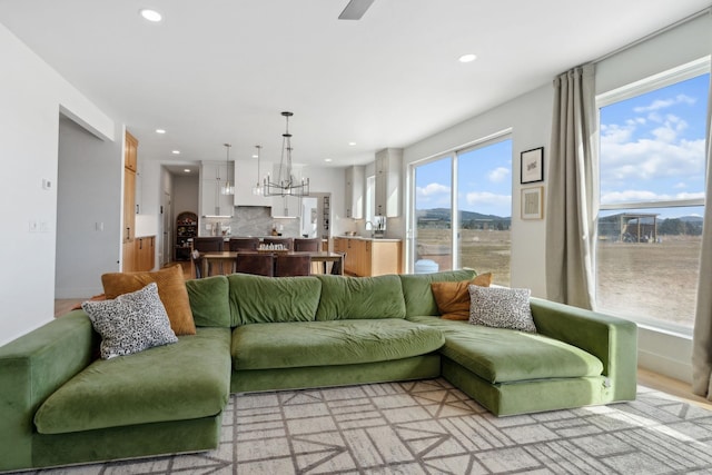 living room with a chandelier, recessed lighting, and baseboards