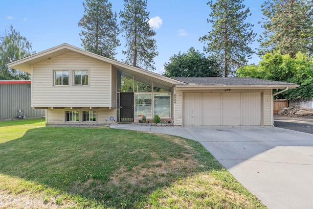 view of front of property featuring an attached garage, driveway, and a front yard