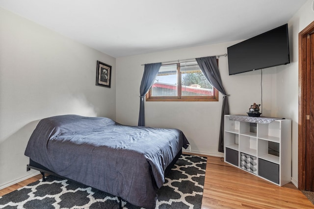 bedroom with light wood-type flooring and baseboards