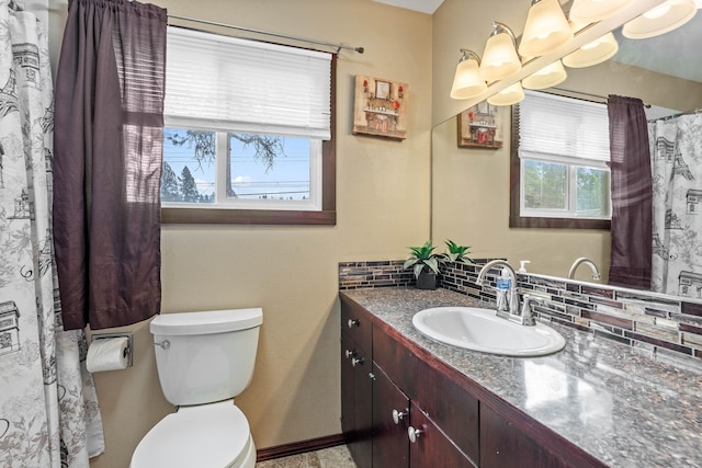 full bath featuring decorative backsplash, toilet, vanity, and baseboards