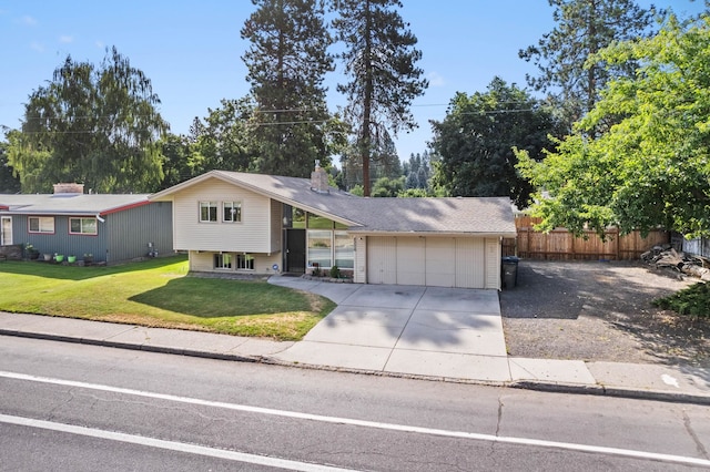 view of front of property with an attached garage, driveway, a front yard, and fence