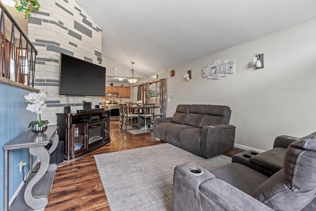 living area with dark wood-style floors, baseboards, a textured ceiling, and lofted ceiling