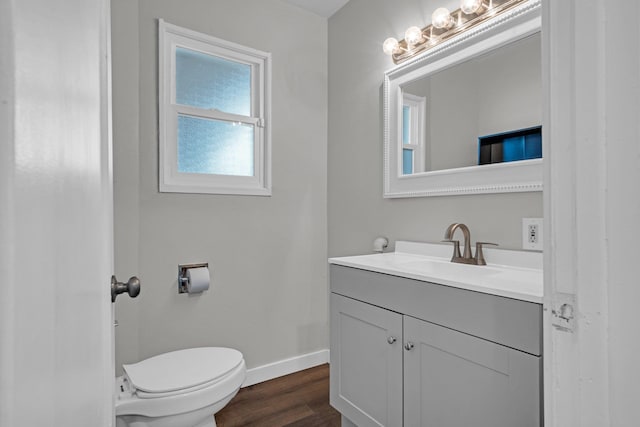 bathroom featuring vanity, toilet, wood finished floors, and baseboards