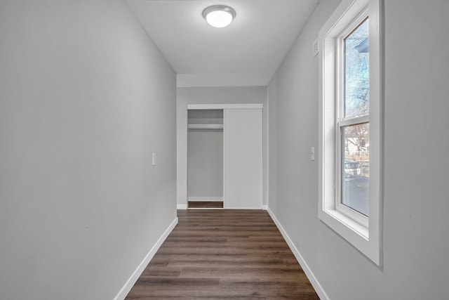 hallway with baseboards and dark wood-style flooring