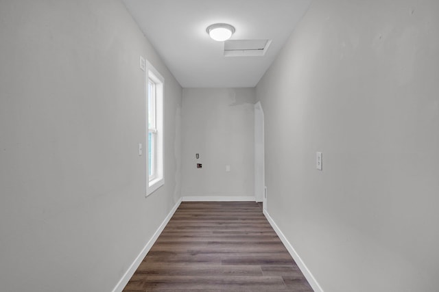 corridor featuring dark wood finished floors, attic access, and baseboards