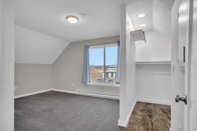 additional living space featuring a baseboard heating unit, a textured ceiling, and vaulted ceiling