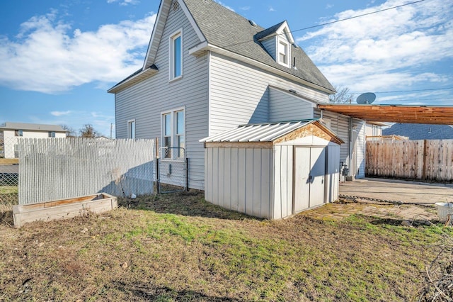 2523 N Nevada St, Spokane, WA 99207 - back of property featuring a storage unit, a fenced backyard, an outbuilding, and a shingled roof