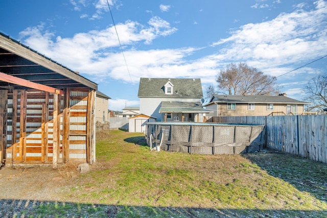 view of yard with a storage shed, an outbuilding, a fenced backyard, and a fenced in pool