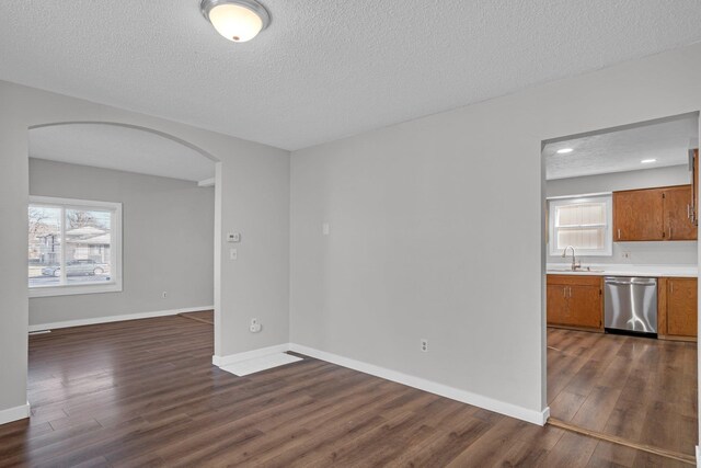 2523 N Nevada St, Spokane, WA 99207 - interior space with a sink, arched walkways, a textured ceiling, baseboards, and dark wood-type flooring