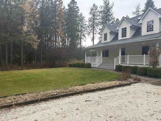 view of front of home with a porch, a shingled roof, and a front lawn