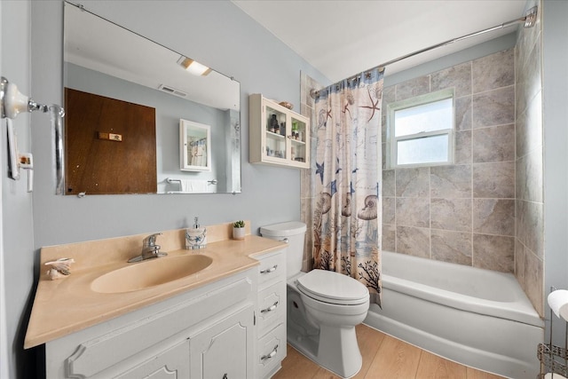 full bath featuring vanity, wood finished floors, visible vents, shower / bath combo, and toilet