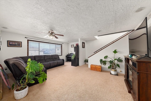 living area with carpet flooring, a ceiling fan, and a textured ceiling