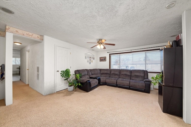 living room featuring visible vents, light carpet, a textured ceiling, and a ceiling fan