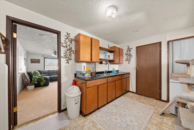 kitchen featuring dark countertops, brown cabinetry, a textured ceiling, a ceiling fan, and open shelves