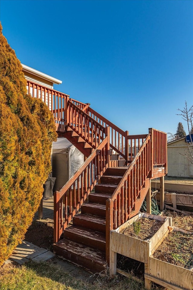 deck featuring stairs and a vegetable garden