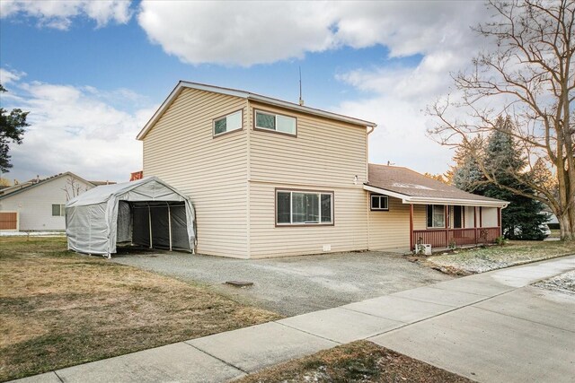 view of front of home featuring a porch and gravel driveway