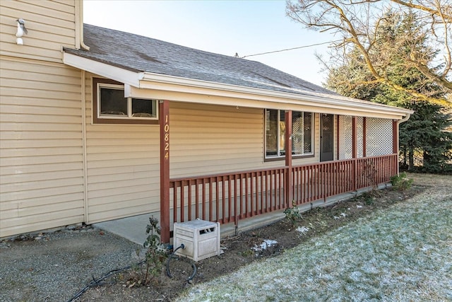 view of home's exterior featuring a porch and a shingled roof