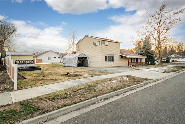 traditional-style house featuring concrete driveway and a front yard