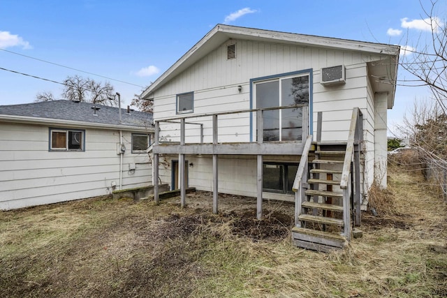 rear view of property with a wall mounted AC and stairs