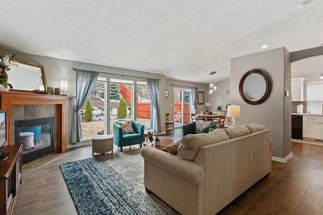 living room with baseboards, wood finished floors, and a tile fireplace