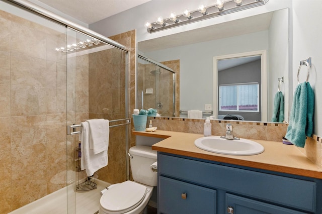 bathroom featuring vanity, toilet, and a shower stall