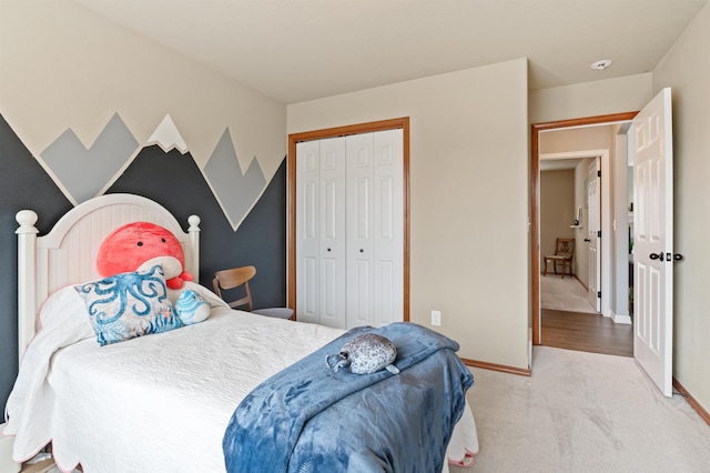 carpeted bedroom with a closet and baseboards