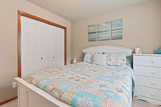 bedroom featuring light colored carpet, a closet, and baseboards