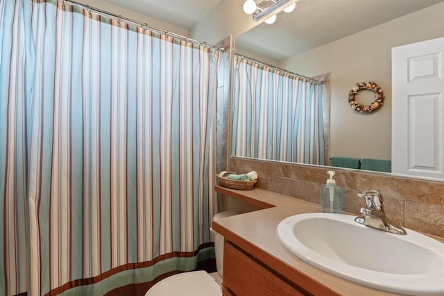 full bath with vanity, toilet, and backsplash