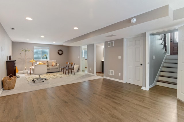 unfurnished living room with recessed lighting, visible vents, wood finished floors, and stairs