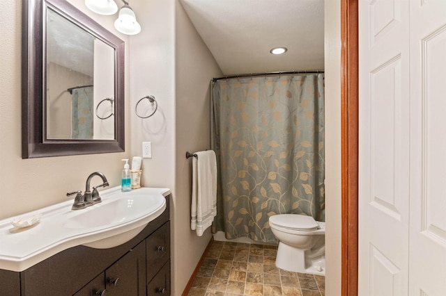 bathroom featuring vanity, toilet, and stone finish flooring