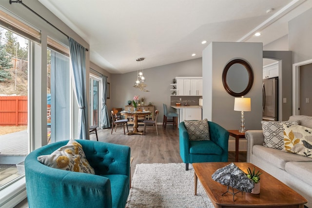 living area featuring plenty of natural light, recessed lighting, light wood-style floors, and vaulted ceiling