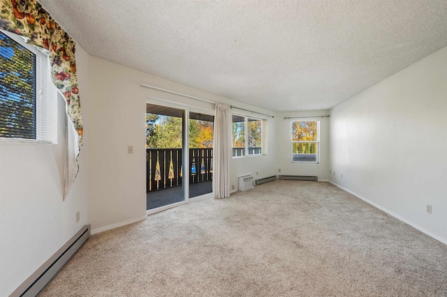 carpeted spare room with a textured ceiling, baseboards, and a baseboard radiator