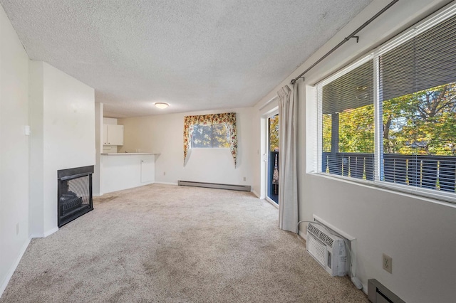 unfurnished living room featuring a baseboard heating unit, an AC wall unit, carpet flooring, a fireplace, and a textured ceiling