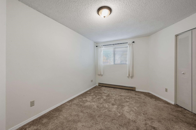 spare room with a baseboard heating unit, baseboards, carpet floors, and a textured ceiling