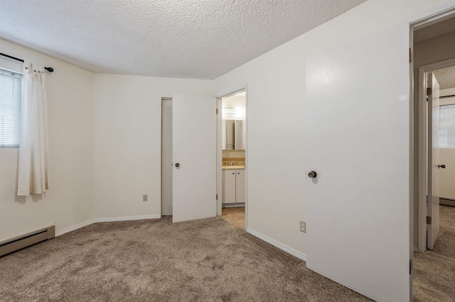 unfurnished bedroom featuring carpet floors, ensuite bath, a sink, a textured ceiling, and a baseboard heating unit