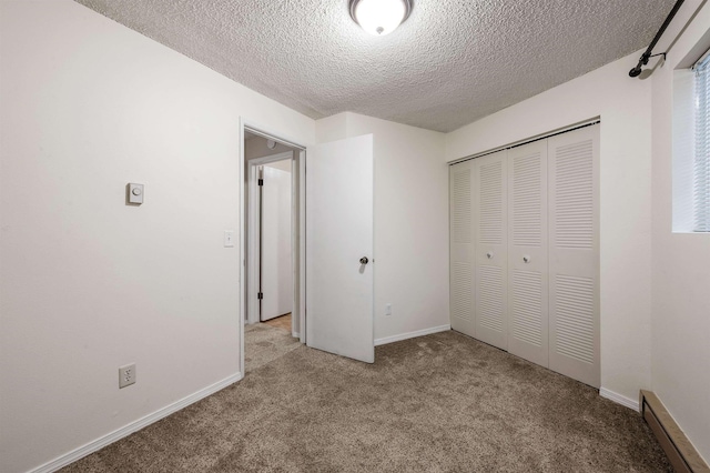 unfurnished bedroom with a closet, baseboards, carpet, and a textured ceiling