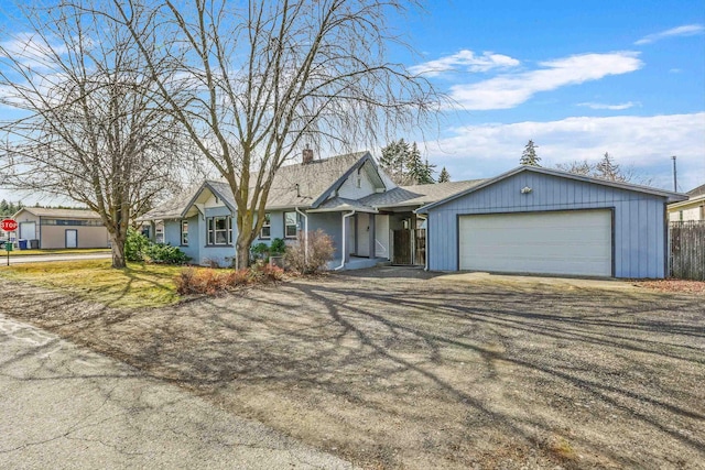 ranch-style house featuring fence, a garage, driveway, and a chimney