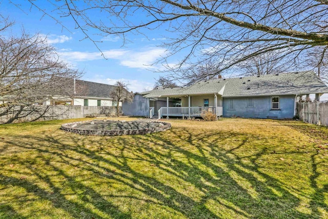 back of house featuring a yard, a wooden deck, and a fenced backyard